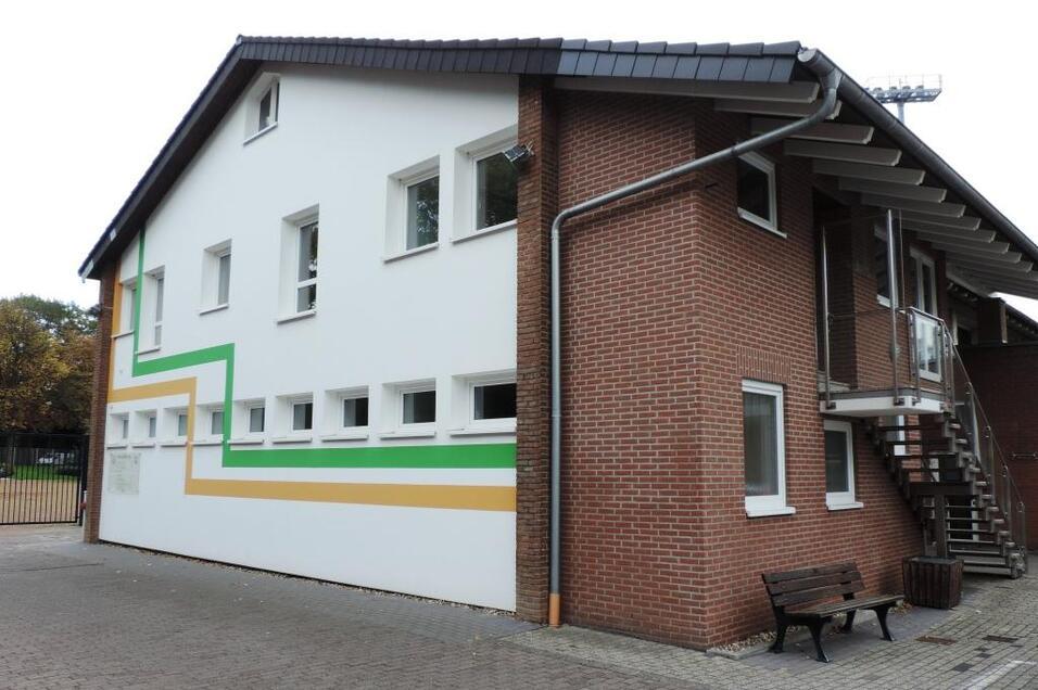 Eckansicht eines modernen Gebäudes mit einer weißen Fassade und bunten Linien sowie einer Treppe an der Seite.