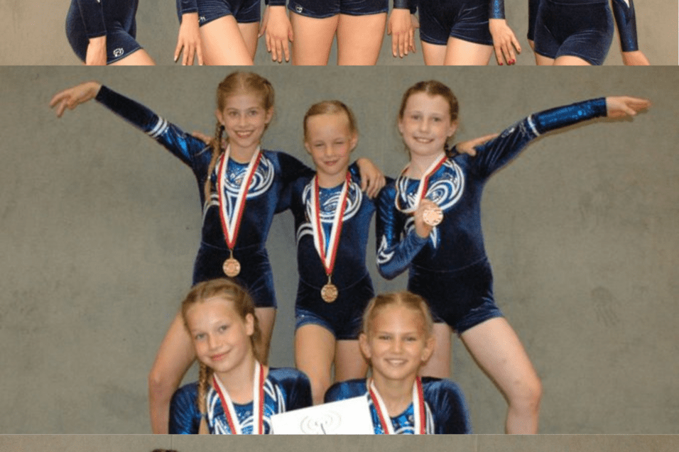 Sechs Turnerinnen in blauen Wettkampfanz&uuml;gen mit Medaillen posieren in drei Gruppen vor neutralem Hintergrund.