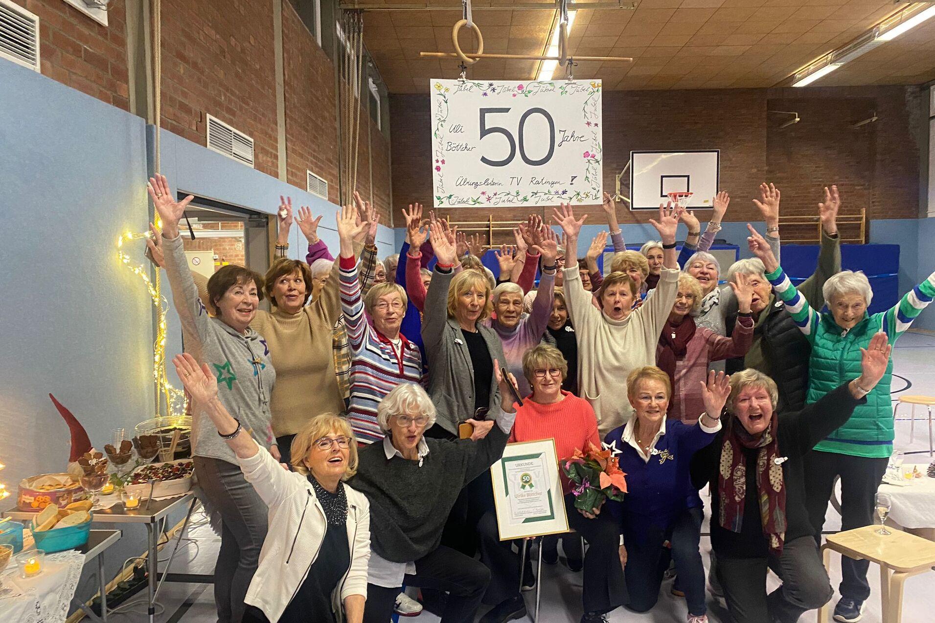 Gruppenshot von Frauen in einer Sporthalle, die jubilierend ihre Hände heben, um 50 Jahre TV Rahlingen zu feiern.