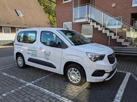 Wei&szlig;er Transporter des Sportzentrums Ost auf einem Parkplatz vor einem Geb&auml;ude mit Treppe.