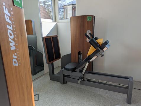 Modernes Fitnessgerät von Dr. Wolff mit verstellbarem Sitz und Rückenlehne in einem gut beleuchteten Raum.